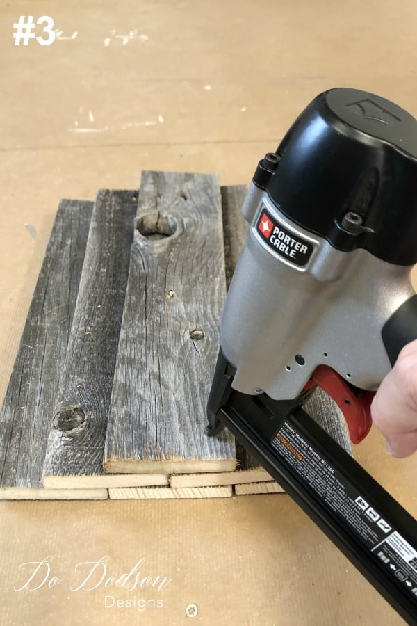 The #3 step for making DIY wood pumpkins is to stack the last board on top of the last 2 and them secure them using a stapler. Flip it over and continue securing the wood pumpkin with the staple gun from behind.
