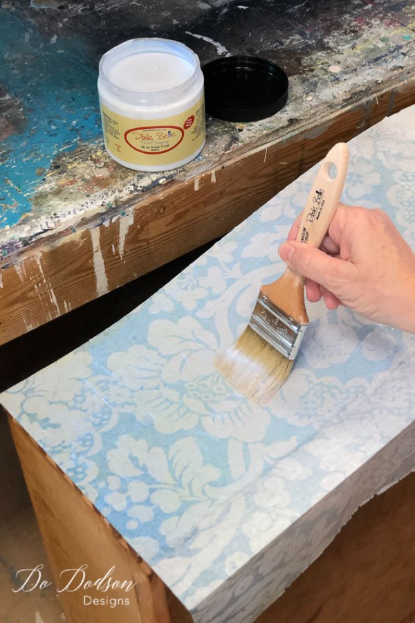 Add another layer of the top coat over the decoupage tissue paper on your wood furniture as a sealer. 