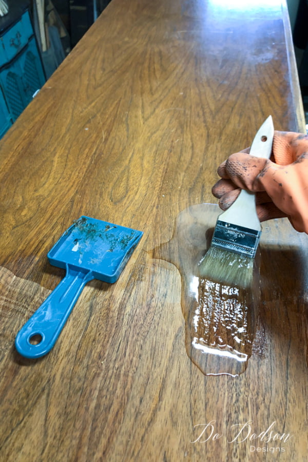 Apply a liberal amount of the gel stripper with a disposable paintbrush. Wait the listed time recommended on the product and test the area by gently scrapping back the old finish in the direction of the wood grain.
