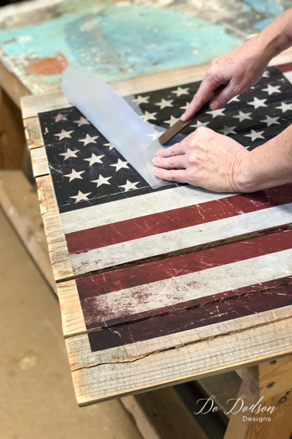 Of course, I could have just painted this American flag pallet sign but I found this transfer and I wanted to try it on a pallet. I have used them on painted furniture and they work great so I was ready to find out how well it would stick to a rough surface. The application is simple... peel off the backing and rub it on. This transfer came in two pieces so be sure to measure where you want it before applying the sticky side to the wood.