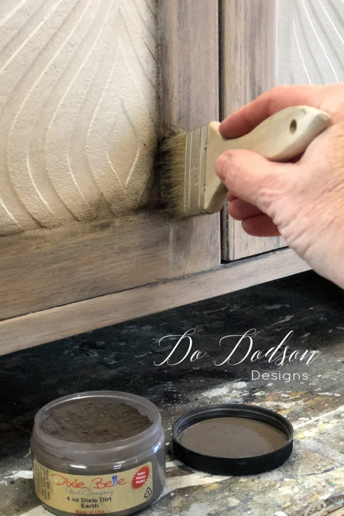 Adding aging dust to the corners of this cabinet dresser gave it more of a cohesive feel. It transitioned the textured wallpaper nicely on this furniture makeover. 