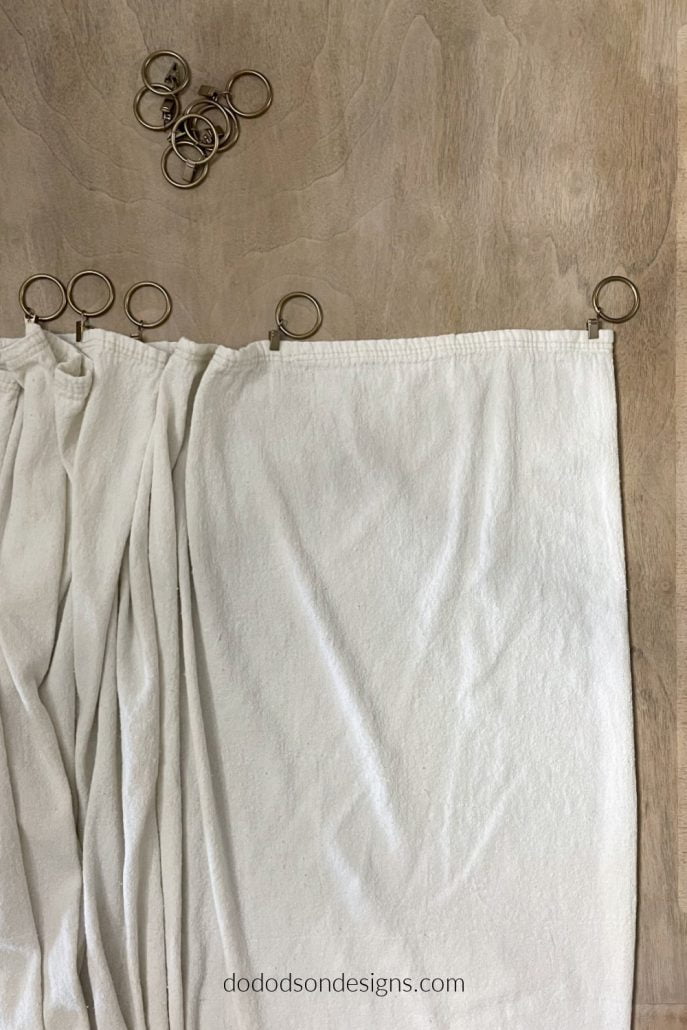 Space the rig clips uniformly for the best look when hanging your DIY drop cloth curtains.